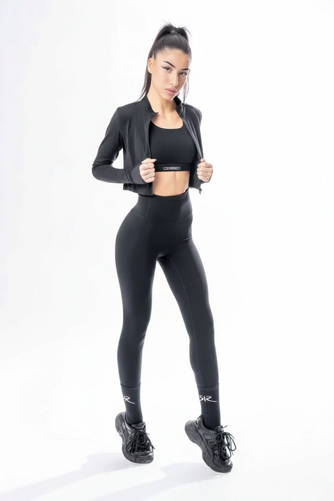 Woman wearing a black athletic outfit on a white background